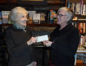 Paula Steige of Macdonald Book Shop presents a $2,000 donation form the Rocky Card to Mary Mesropian, director of Estes Valley Victim Advocates.